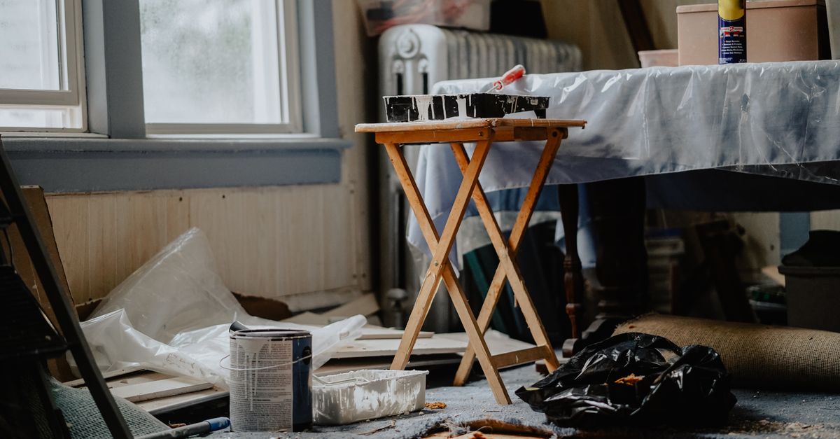 Pièce d'appartement en cours de rénovation avec pots de peinture et tréteau