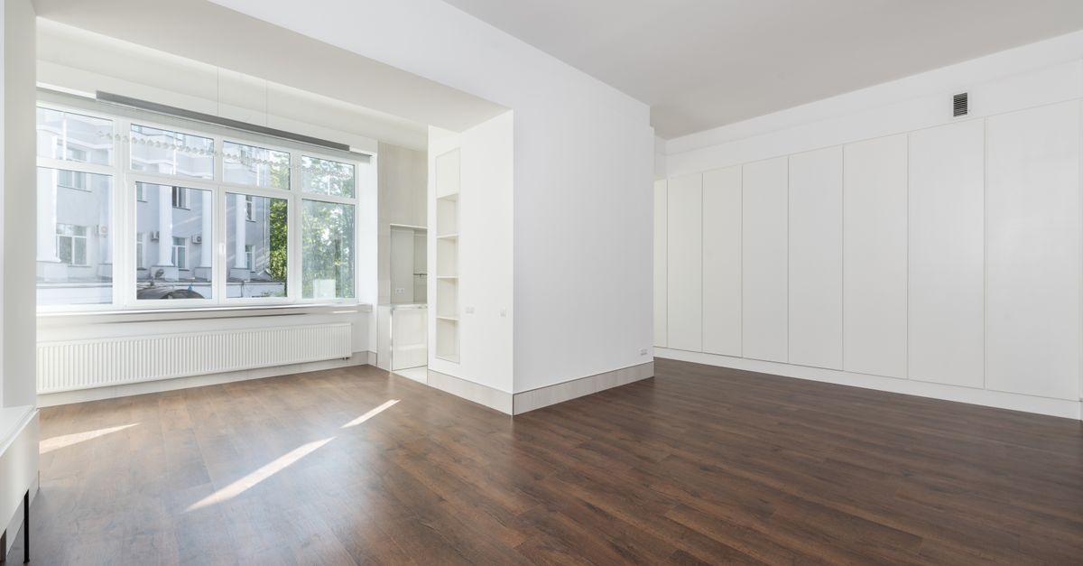 Appartement vide lumineux avec parquet et grande fenêtre
